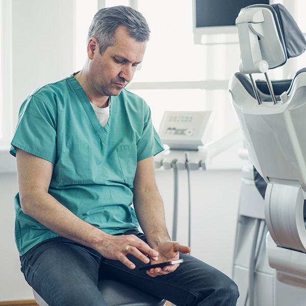 Dentist texting on mobile phone